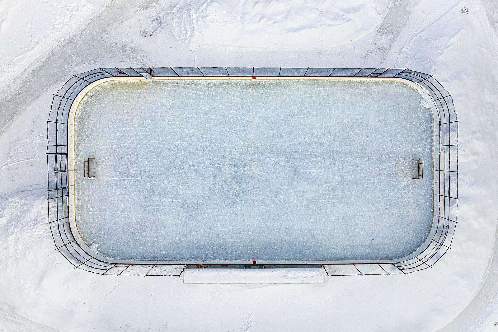 An outdoor rink in snow seen straight down from above