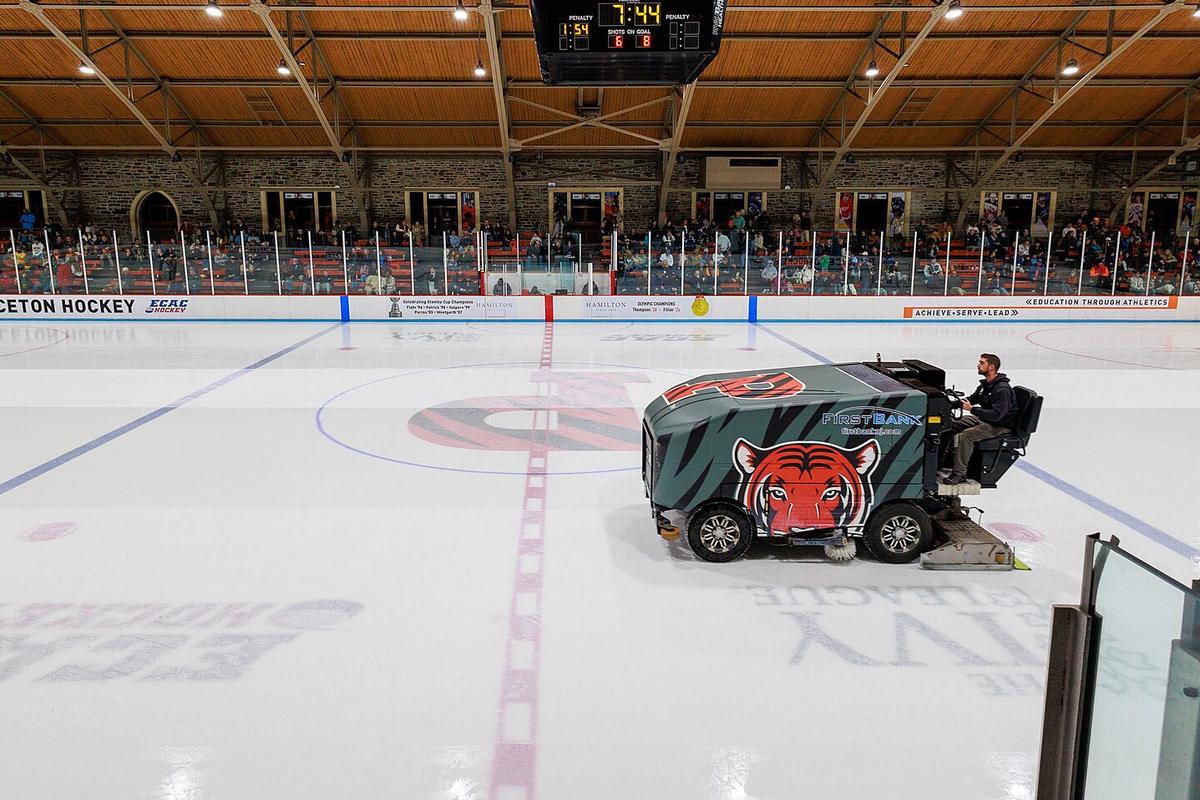 A resurfacer crossing centre ice in an empty college rink